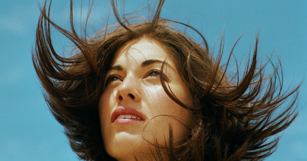 close-up van het gezicht van een vrouw met de haren in de wind