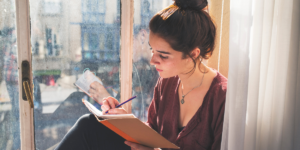 vrouw reflecteert op het jaar en schrijft in een boekje