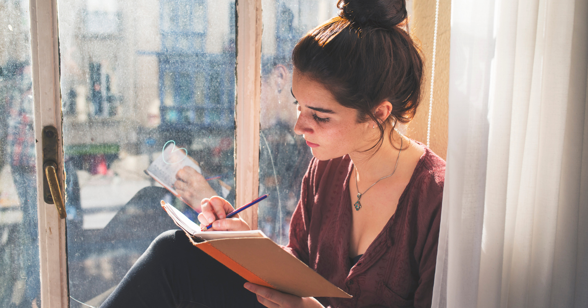 vrouw reflecteert op het jaar en schrijft in een boekje