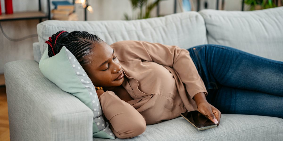 vrouw twijfelt over iemands uitnodiging afslaan omdat ze moe is en op de bank wil liggen