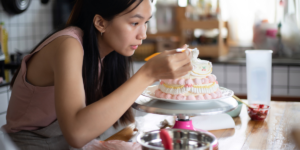 Vrouw die een taart aan het decoreren is