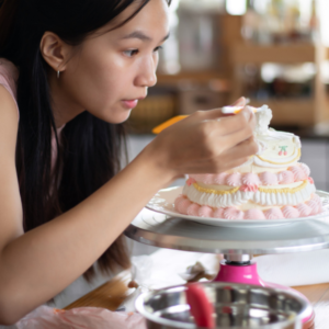 Vrouw die een taart aan het decoreren is