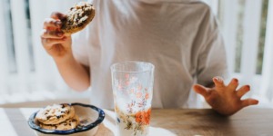 persoon is koekjes aan het eten, wat de bloedsuikerspiegel verhoogt