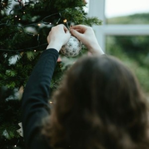 vrouw hangt kerstversiering op